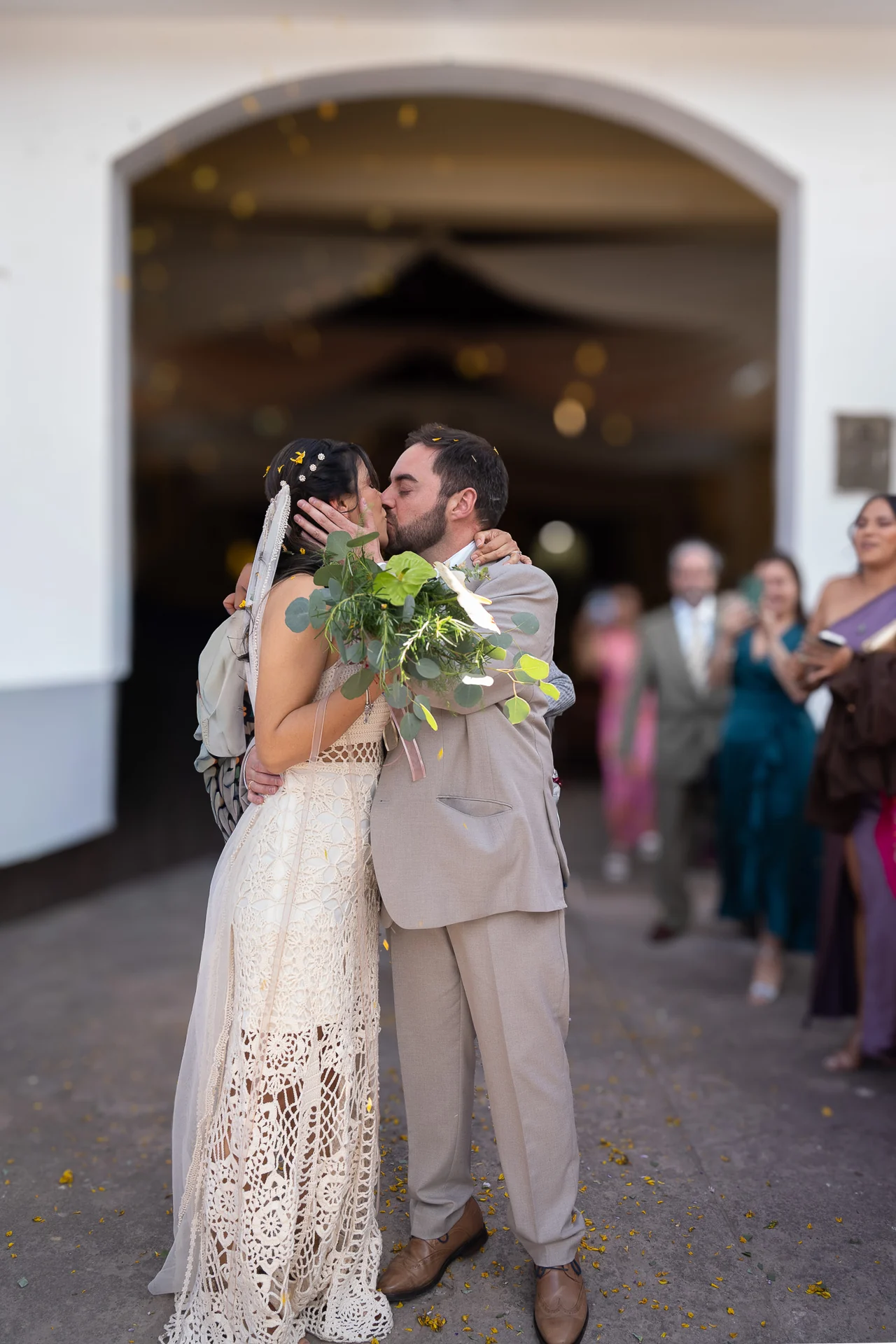 Un beso de los recién casados a la salida de la iglesia